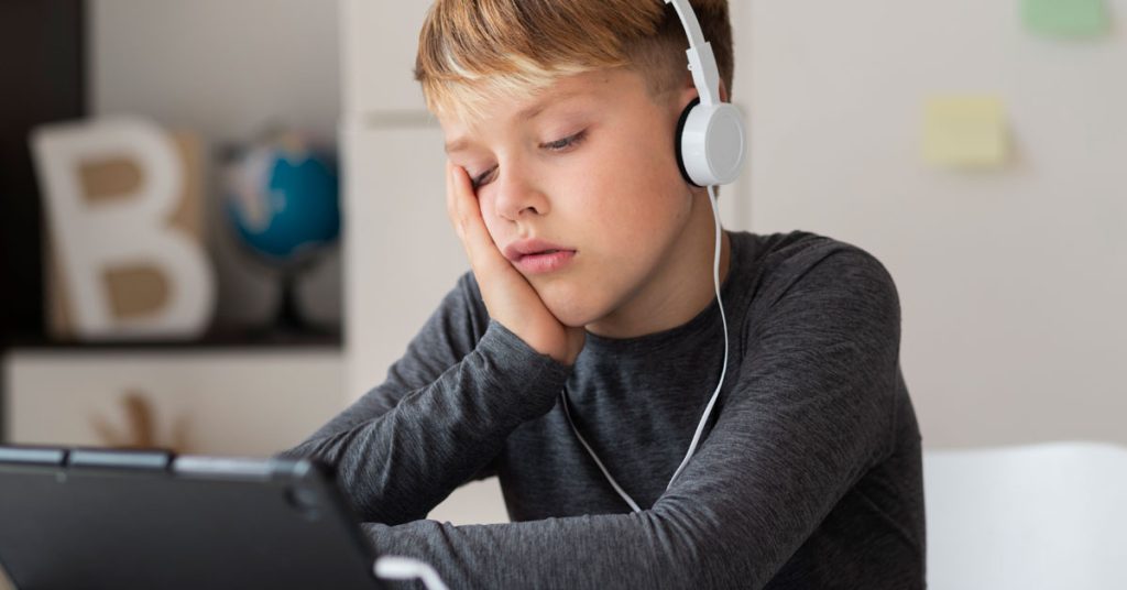 Niño aburrido en una clase de inglés tradicional