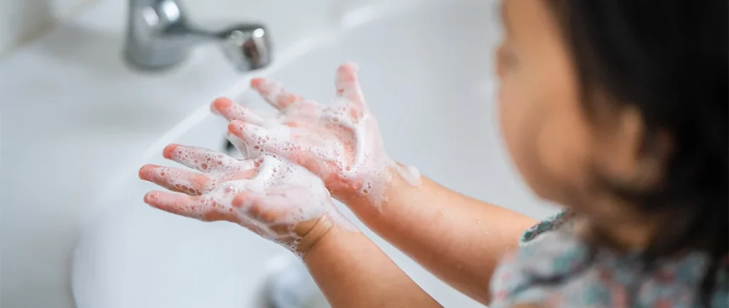 Niño lavándose las manos en el baño