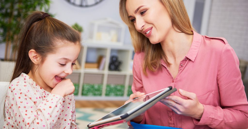 Madre e hija usando una laptop para aprender inglés en línea