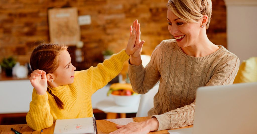 Niña celebrando con su mamá tras leer un libro en inglés