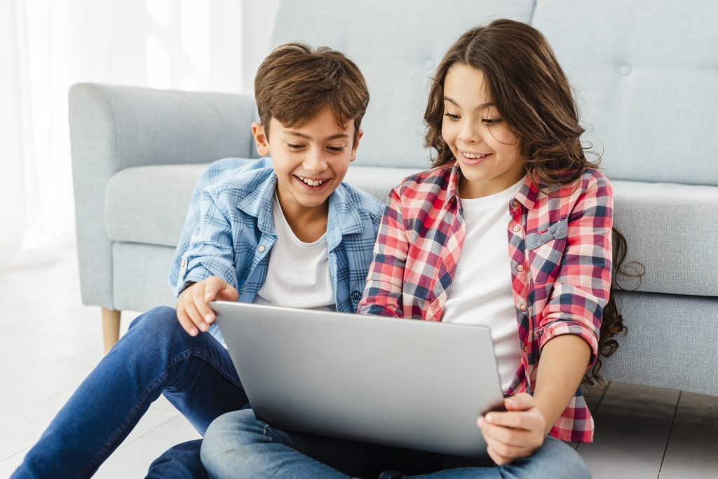 Hermanos jóvenes aprendiendo inglés con la laptop