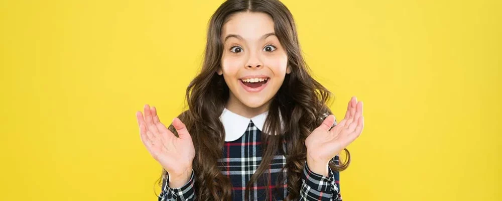amazing-news-happy-smiling-kid-portrait-emotions-emotional-expression-just-happy-small-girl-classy-checkered-dress-child-long-curly-hair-happy-schoolgirl-stylish-uniform-childhood-concept
