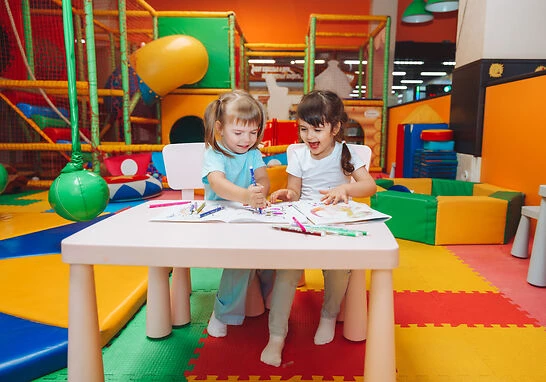 ninas estan sentadas mesa dibuja - English4Kids